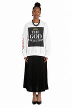 Person wearing a white sweatshirt with text and a black skirt on a white background