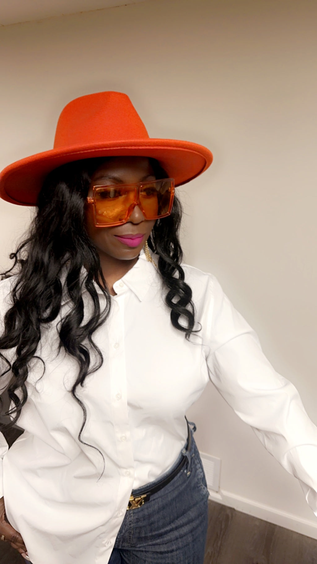 Woman in Orange with long hair white shirt and jeans wearing  Orange Oversize Shades 
