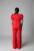 Person wearing a red outfit standing in a living room.